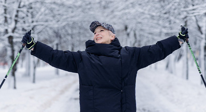 Une femme qui a la soixantaine, heureuse au ski