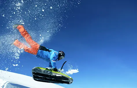 Homme qui dévale une piste en luge