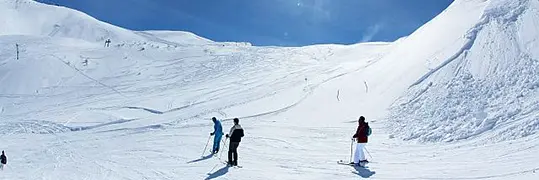 Trois personnes qui font du ski de fond à travers les montagnes en hiver