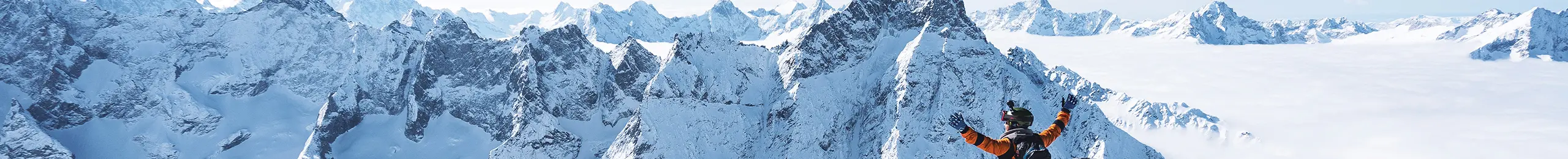 Un homme contemple un paysage montagneux et enneigé