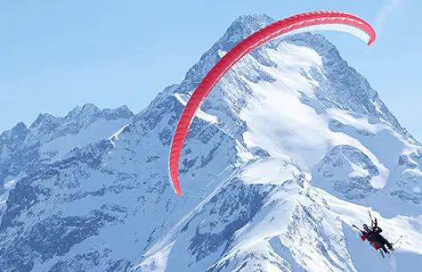 Une personne qui fait du parachute à travers les montagnes