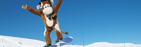 Une personne déguisée en vache qui fait du snowboard