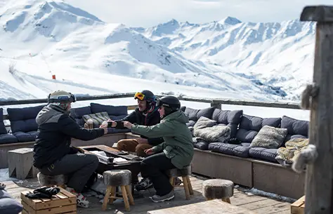 Des amis profite d'un collation avec une vue sur les montagnes enneigées