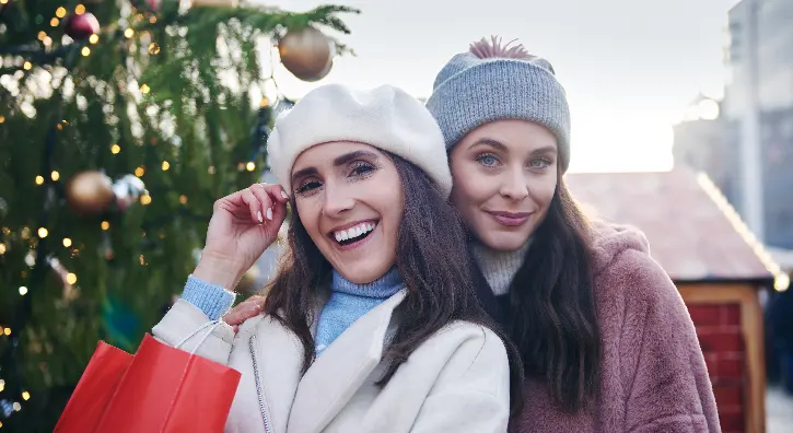 Deux amies qui prennent la pose devant des décorations de noël