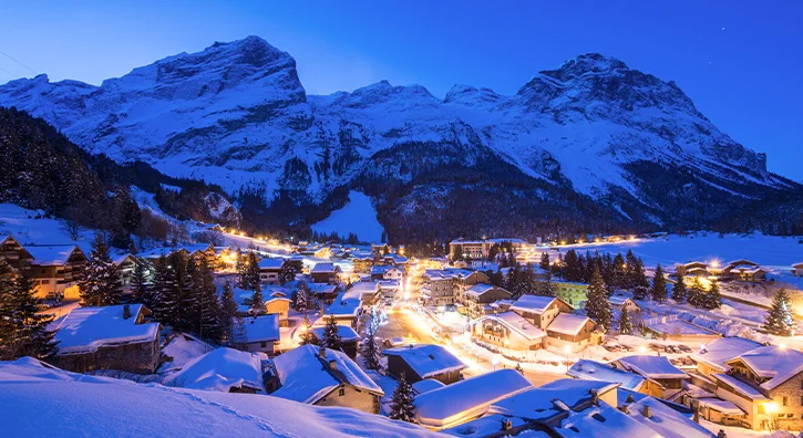 Station de ski sous la neige éclairée par ses lumières la nuit
