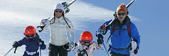 Une famille s'apprêtant à dévaler une piste au ski