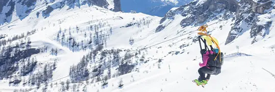 Un couple de personnes qui font de la tyrolienne à travers les montagnes