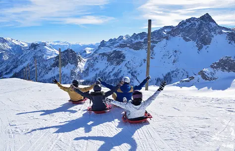 Un groupe de personnes qui s'apprêtent à faire une descente en luge