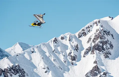 Une personne qui pratique un sport extrême entre les montagnes enneigées