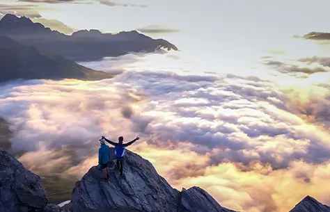 Des personnes qui contemple la vue du haut d'une montagne