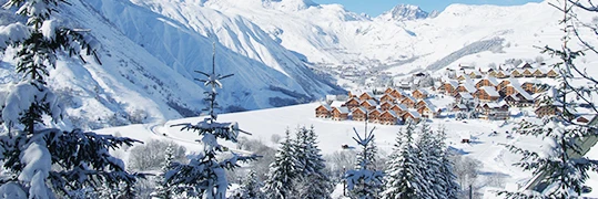 Vue sur la station de ski à travers la forêt enneigée