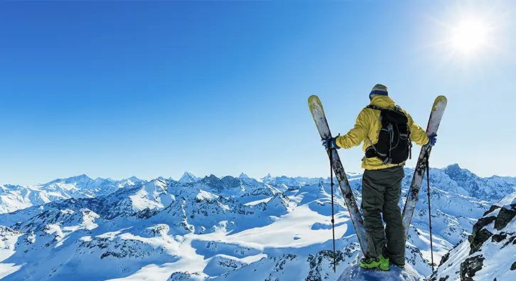 Un homme contemple un paysage de montagnes enneigées