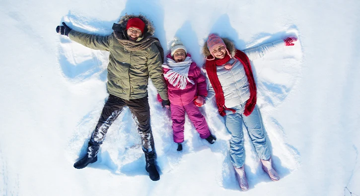 Une famille qui dessine un ange de neige