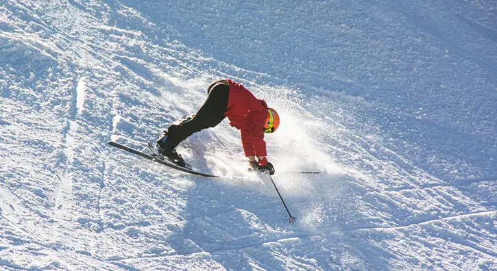 Un skieur qui fait une chute sur la piste de ski