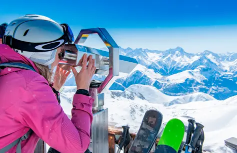 Une femme qui admire la vue d'un paysage montagneux et enneigé