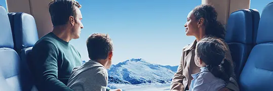 Une famille dans le train qui admire le paysage d'un paysage de montagnes enneigées
