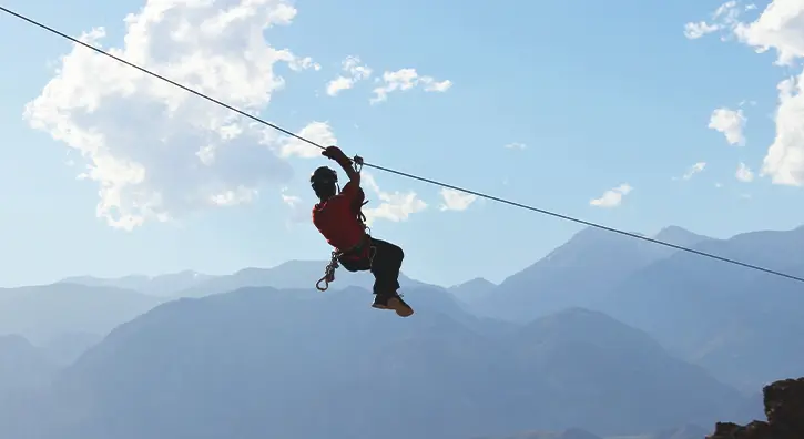 Faire de la tyrolienne à travers les montagnes